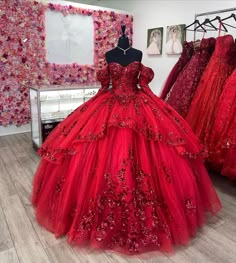 Celebrate your quinceanera in style with this breathtaking red ball gown. The voluminous tulle fabric creates a stunning, full skirt that effortlessly twirls with every step, while the sweeping train adds a touch of drama and elegance to your grand entrance. The off-the-shoulder neckline offers a perfect blend of grace and allure, while the sleeveless design ensures ease of movement throughout the festivities. The intricate applique details adorn the bodice and skirt, enhancing the gown’s timele Red Quince Court Dresses, Queincearra Dresses Red, Quiencera Dresses Red And Gold, Red Black And White Quinceanera Dress, Red Quince Dress With Sleeves, Spider Man Quince Dress, Red And Gold Dress Quinceanera, Quencinera Dresses Red, Spiderman Quinceanera Dress