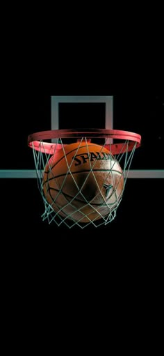 a basketball is in the net with it's reflection on the wall behind it