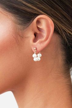 a woman's ear with two pearls on the top and one pearl in the middle