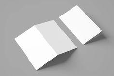 two folded white cards sitting on top of each other