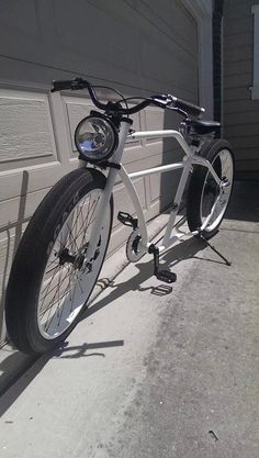 a bicycle parked in front of a garage door next to a driveway with no one on it