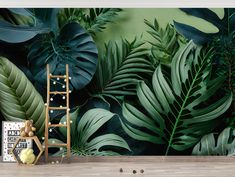 a room with green leaves and a ladder on the floor next to a painting easel