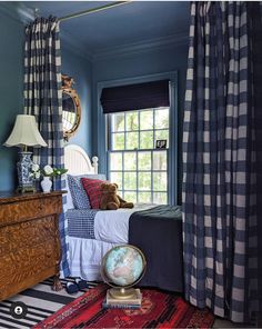 a bedroom with blue walls and plaid curtains