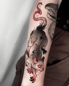 a woman with a tattoo on her arm has an image of a rat and shark