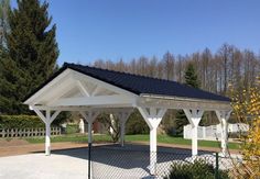 a white gazebo sitting in the middle of a park