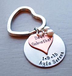 a heart shaped keychain with the words best godmother and two hearts on it