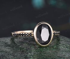 a black and white ring sitting on top of a rock