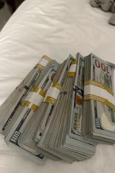 stacks of money sitting on top of a bed