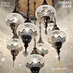 a chandelier hanging from the ceiling with glass globes on it's sides