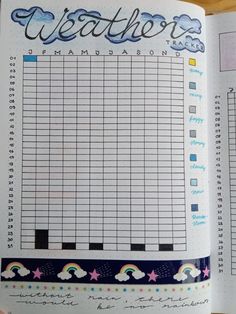 an open planner with rainbows, clouds and stars on it in a book opened to the page