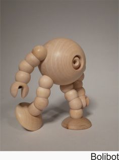 a wooden toy that is standing on one foot and looking at the ground with its legs spread out