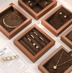 six jewelry boxes with different types of rings and necklaces in them on top of a table