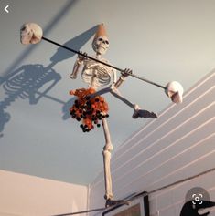 a fake skeleton is hanging from the ceiling with decorations on it's head and arms