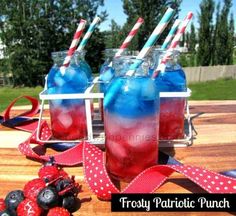 three glasses filled with red, white and blue liquid sitting on top of a wooden table