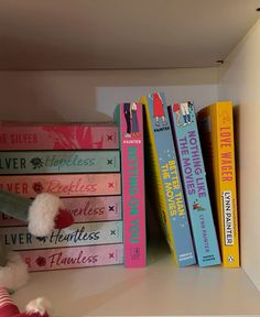 a shelf with books and a stuffed animal on it