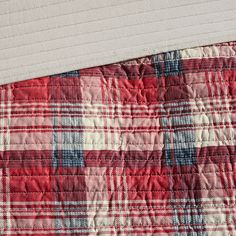 a red and white plaid quilt on top of a bed