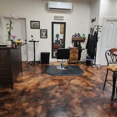 a hair salon with chairs, tables and other items on the floor in front of a mirror