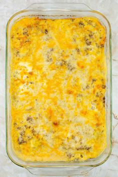 a casserole dish with cheese and meat in it on a marble counter top