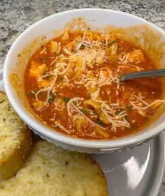 a bowl of soup with bread on the side