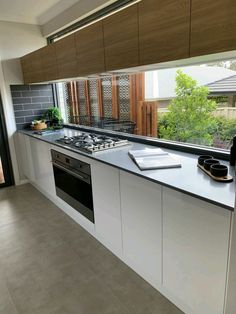 a kitchen with an oven, sink and stove top on the counter in front of a window