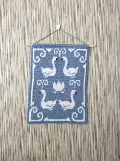 a blue and white wall hanging with ducks on it