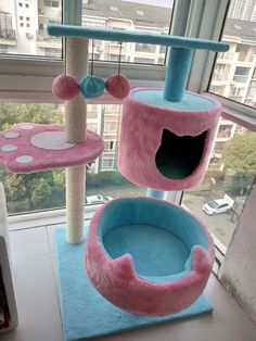 the cat tree is made out of pink and blue material