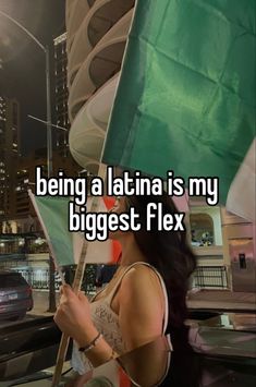 a woman holding a green flag with the words being a latin is my biggest flex