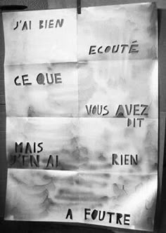 two pieces of paper taped to a wall with words written on it and in french