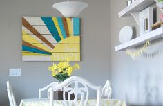 a dining room table with yellow flowers in the center and a happy sign above it