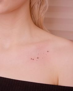 a woman's chest with small stars on the left side of her body,