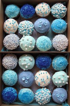 two boxes filled with blue and white cupcakes