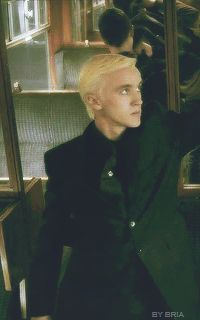 a man with blonde hair wearing a black suit