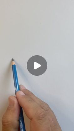 a person holding a pencil in their left hand and writing on the paper with an eraser