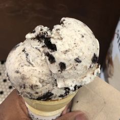 an ice cream sundae with chocolate chip cookies and white icing in a cone