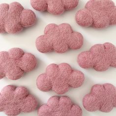 small pink felted clouds on a white surface