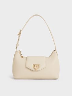 The Arwen makes its return in a classic baguette bag style but with a slouchier silhouette. You will have plenty of room for your everyday essentials and more. Crafted with a push-lock closure flap opening, the polished gold accent adds a glimmer of shine that stands out from the beautiful beige finish -- this piece is an embodiment of minimalist style. Use it as an on-the-go shoulder bag or adjust the strap for a casual crossbody look. Beige Designer Bag, Cream Shoulder Bag, White Leather Shoulder Bag, Purses 2024, Beige Bags, Charles And Keith Bags, Purse Aesthetic, Beige Shoulder Bag, Beige Purse