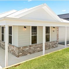 a white house with brick pillars and windows