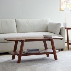 a coffee table sitting on top of a carpeted floor next to a white couch