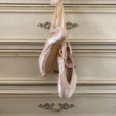 a pair of ballet shoes hanging on a wall