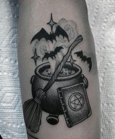 a black and white image of a witch's caulder with bats on it