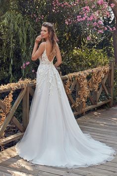 a woman in a wedding dress standing on a bridge