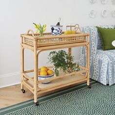 a living room filled with furniture and a plant on top of a wooden table next to a couch