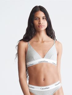 A Calvin Klein icon. This modern cotton bralette is the definition of effortless. Made with super soft and supple cotton stretch blended with modal for all day comfort. Designed with the original Calvin Klein logo band, this is a sporty look that feels sexy everyday.  Material: 53% Cotton, 35% Modal, 12% Elastane. Modern Fitted Calvin Klein Top, Trendy Everyday Sports Bra, Sporty Cotton Sports Bra For Loungewear, Spring Cotton Sports Bra For Loungewear, Cotton Medium Support Sports Bra For Loungewear, Medium Support Cotton Sports Bra For Loungewear, Cotton Sports Bra With Medium Support For Loungewear, Calvin Klein Spring Tops For Everyday Wear, Trendy Cotton Bra For Loungewear