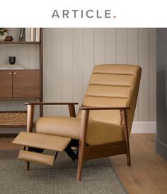 a brown recliner chair sitting on top of a rug next to a book shelf