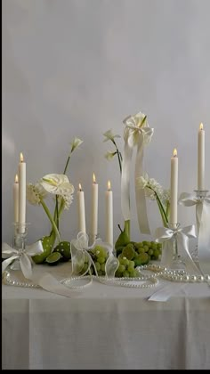 a table topped with white flowers and candles