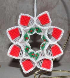 a crocheted christmas ornament hanging from a hook on a table top