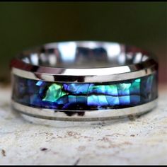 Ring Width: 8mm Metal: Titanium Steel And Silver Features: Scratch And Tarnish Resistant Style: Band Sizes Available 9,10,12 Gender: Men And Women Inlay: Abalone Shell Blue And Green Shimmering - Brand New Box Silver Aesthetic, Retail Jewelry, Shell Ring, Casual Jewelry, Silicone Rings, Titanium Rings, Tungsten Ring, Unisex Ring, Tungsten Carbide