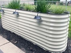 a large metal planter with plants growing in it