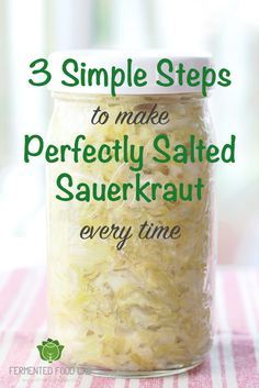 a jar filled with sauerkraut sitting on top of a pink and white table cloth