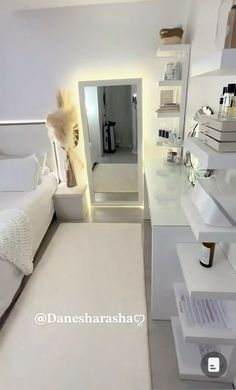 a bedroom with white walls and flooring is shown in this image, there are shelves on either side of the bed